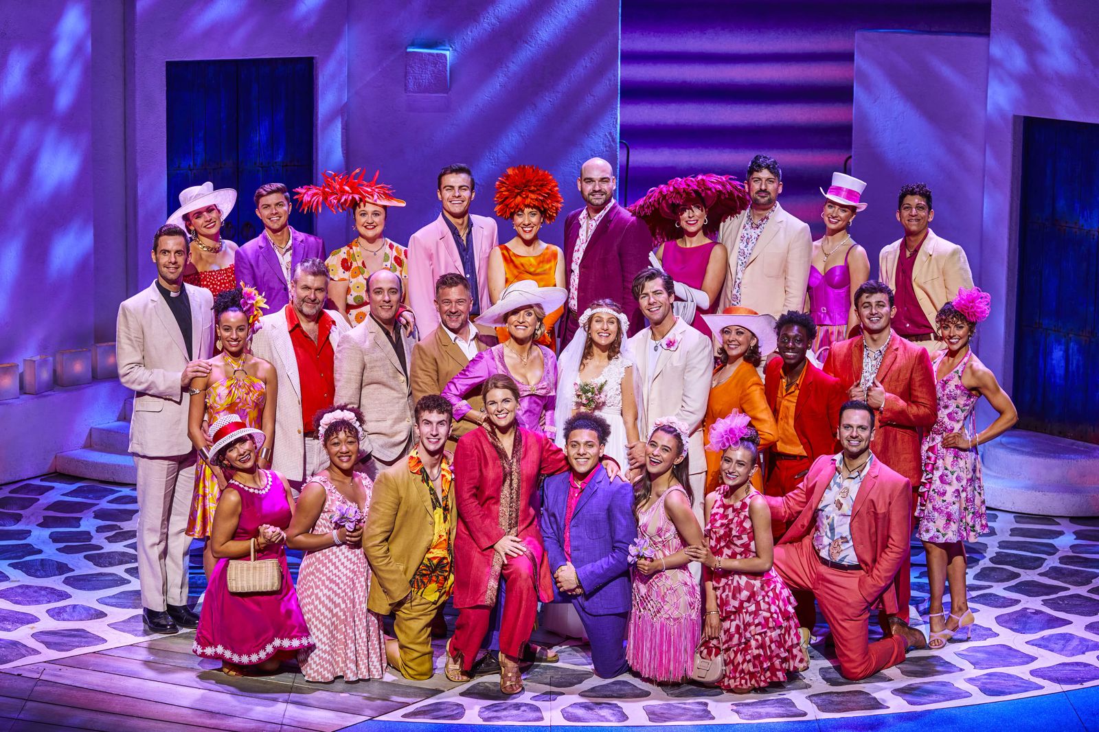 Wide shot of the entire cast of MAMMA MIA! onstage 