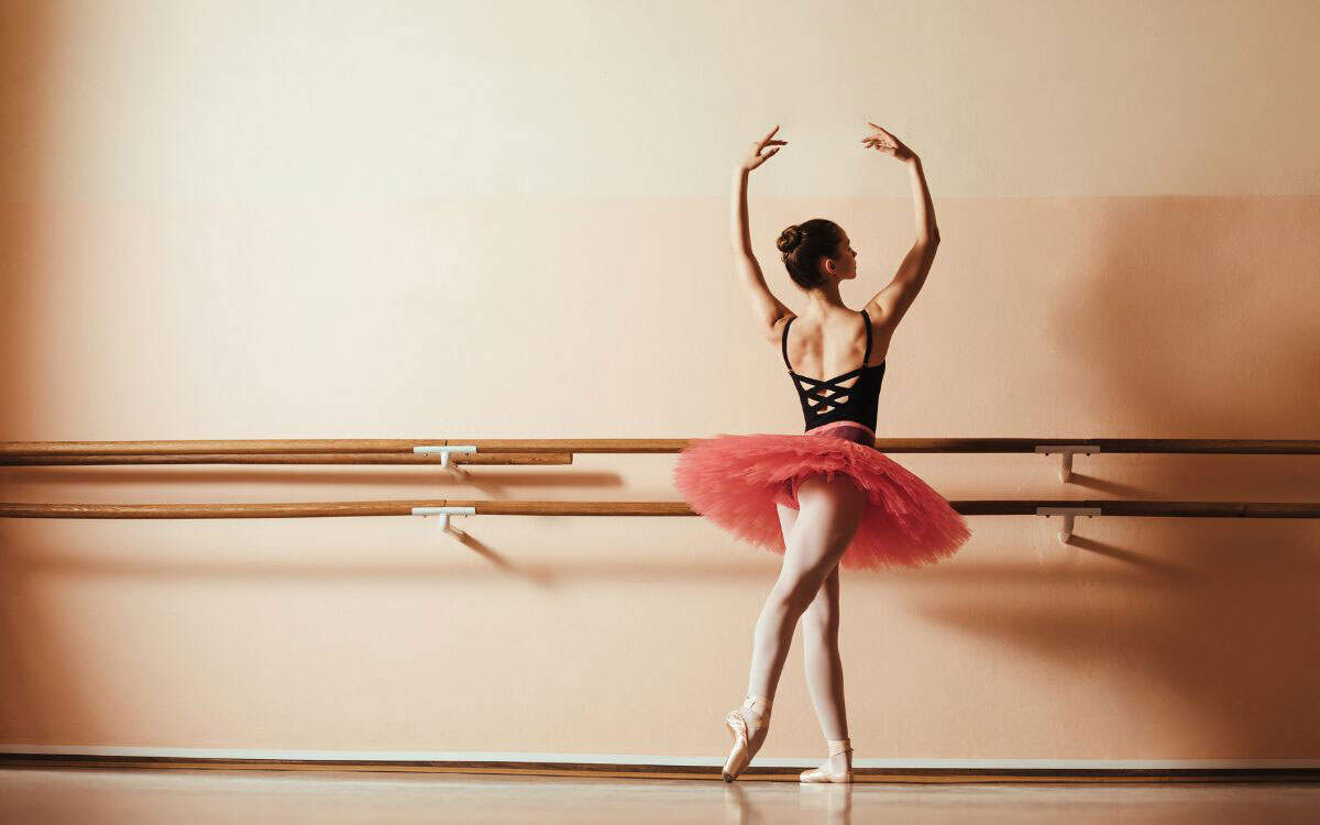 Wide shot of a ballet dancer posing in a studio 