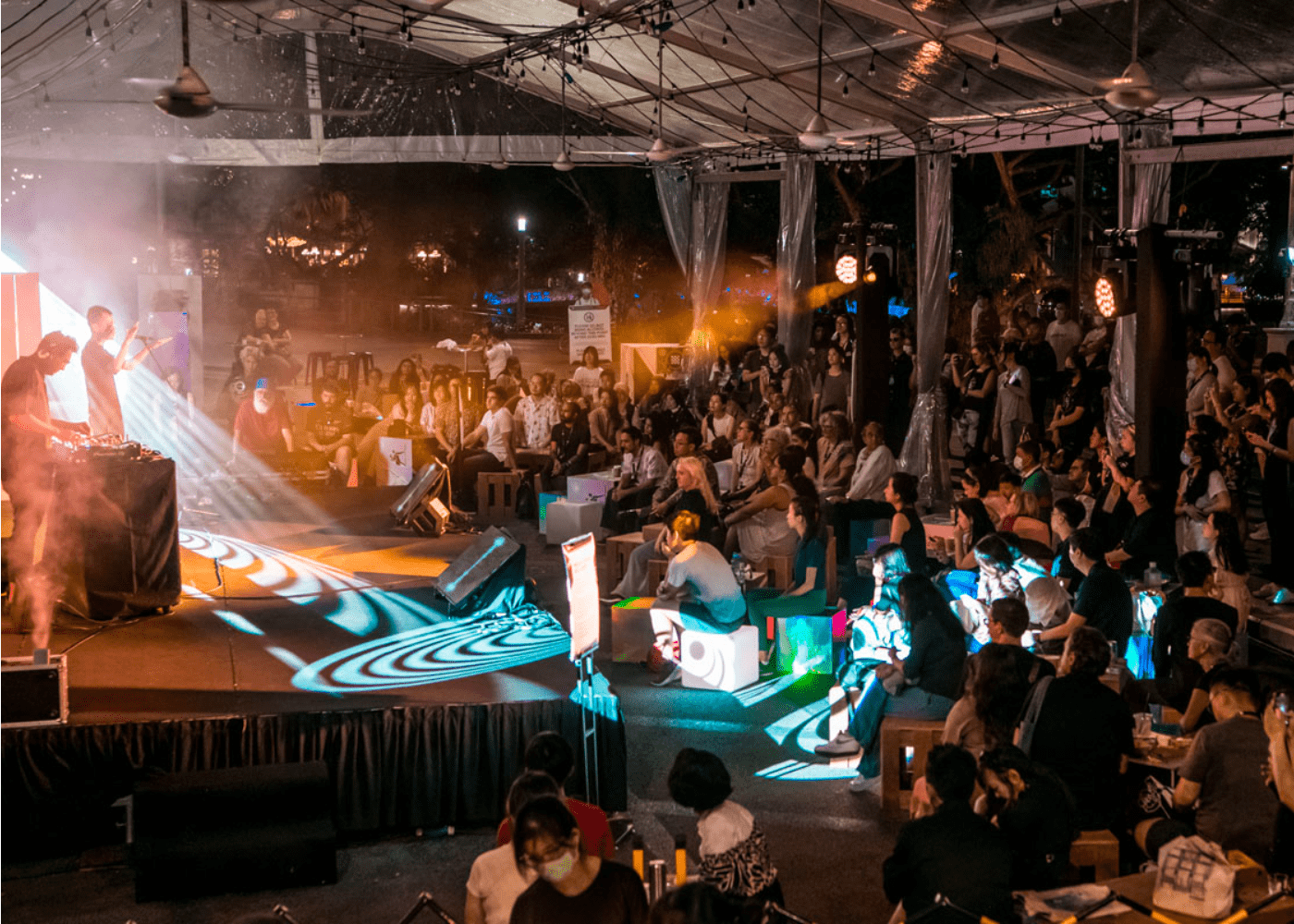 Wide shot of a crowd enjoying a music performance at night