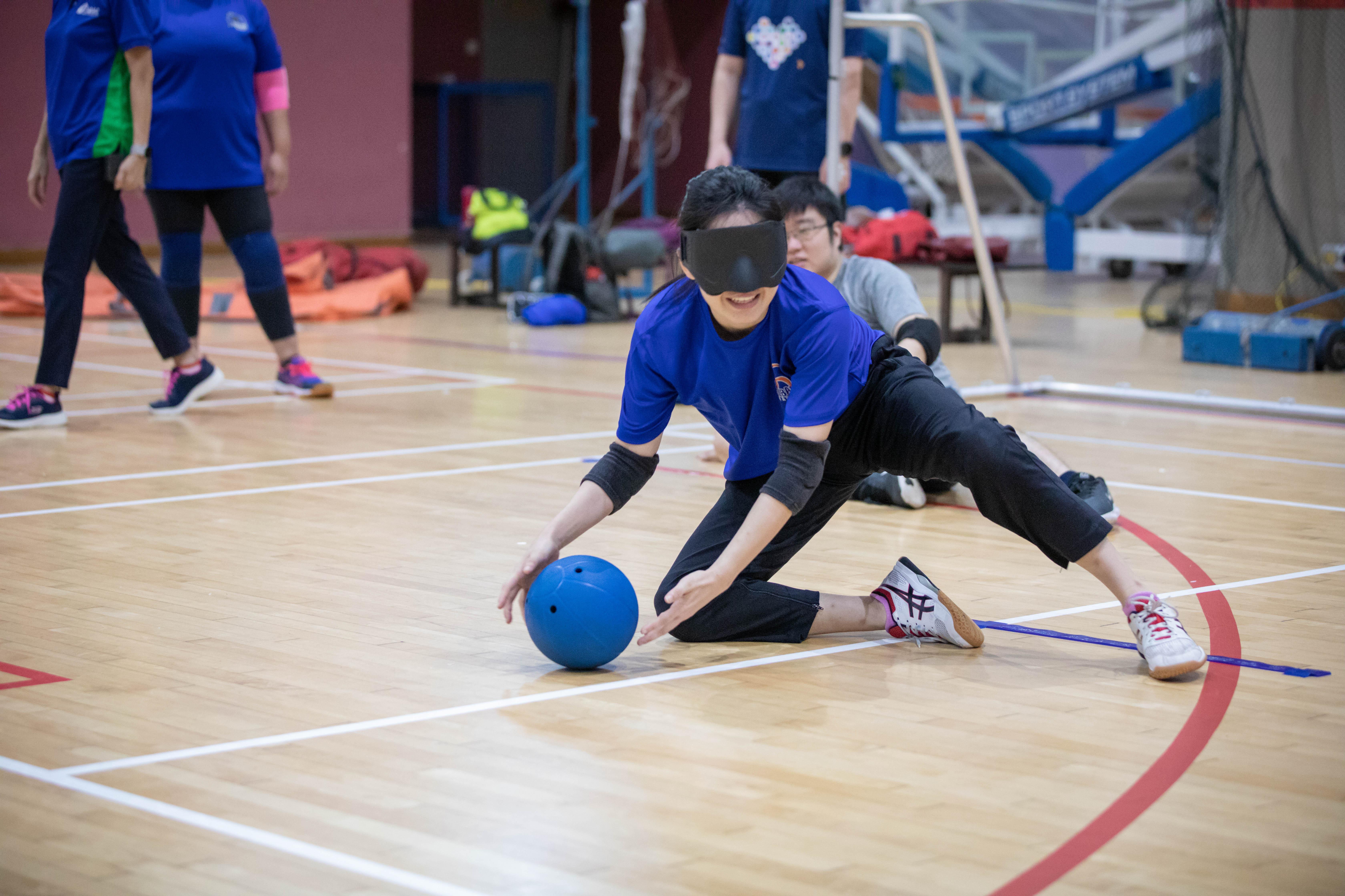 Wide shot of a lady trying out para sports with a blindfold on