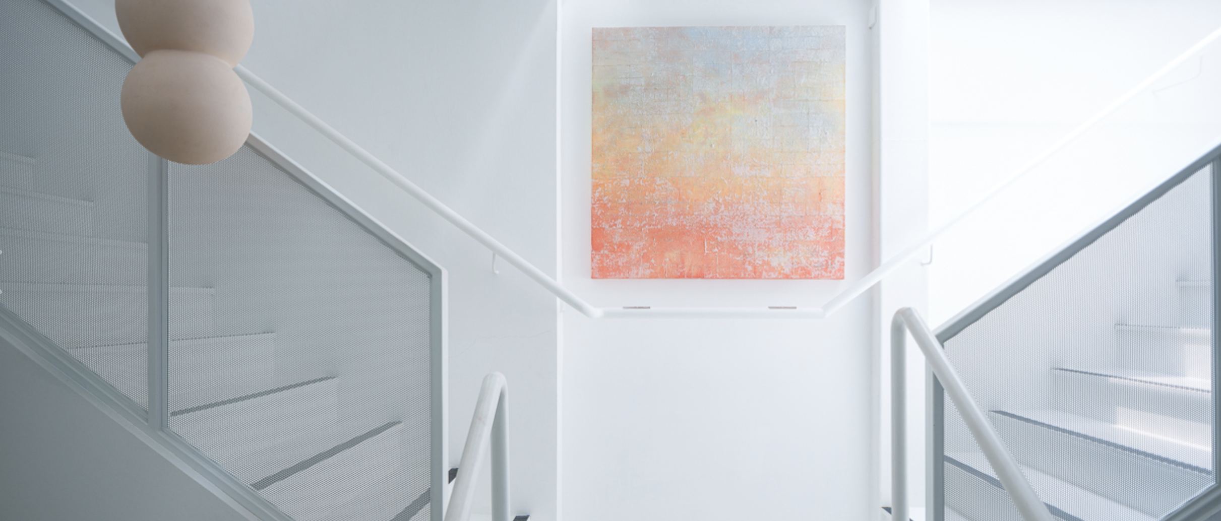 Wide shot of a painting mounted on a wall between two staircases