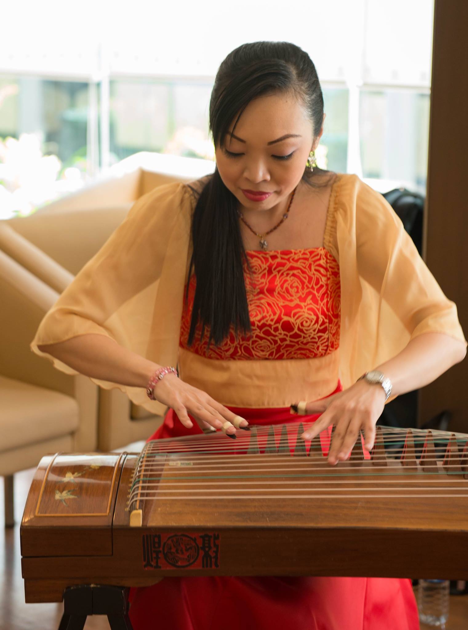 Mid shot of Michella Chua playing the guzheng