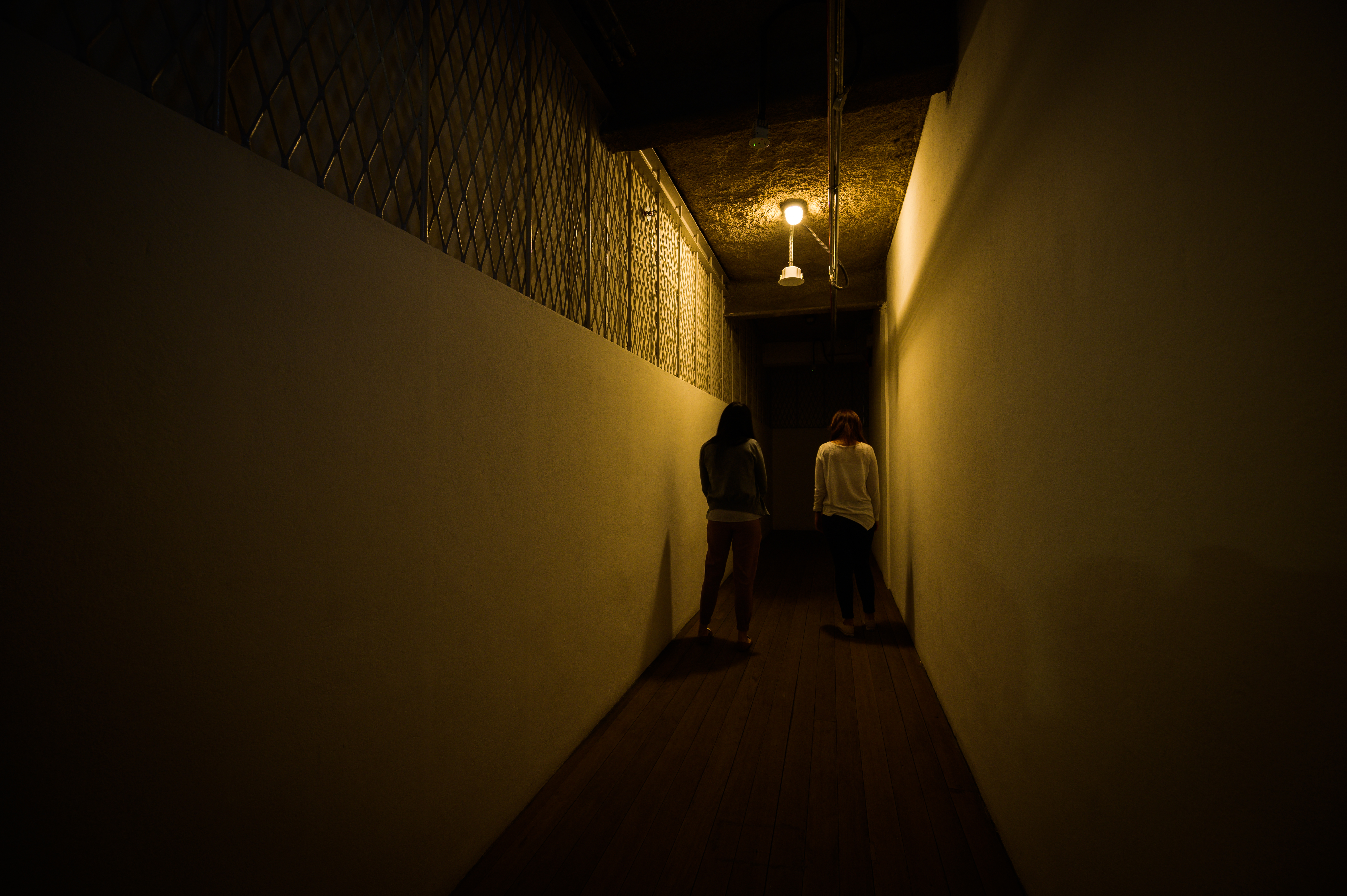 Wide shot of two ladies at the end of the corridor leading to the courthouse