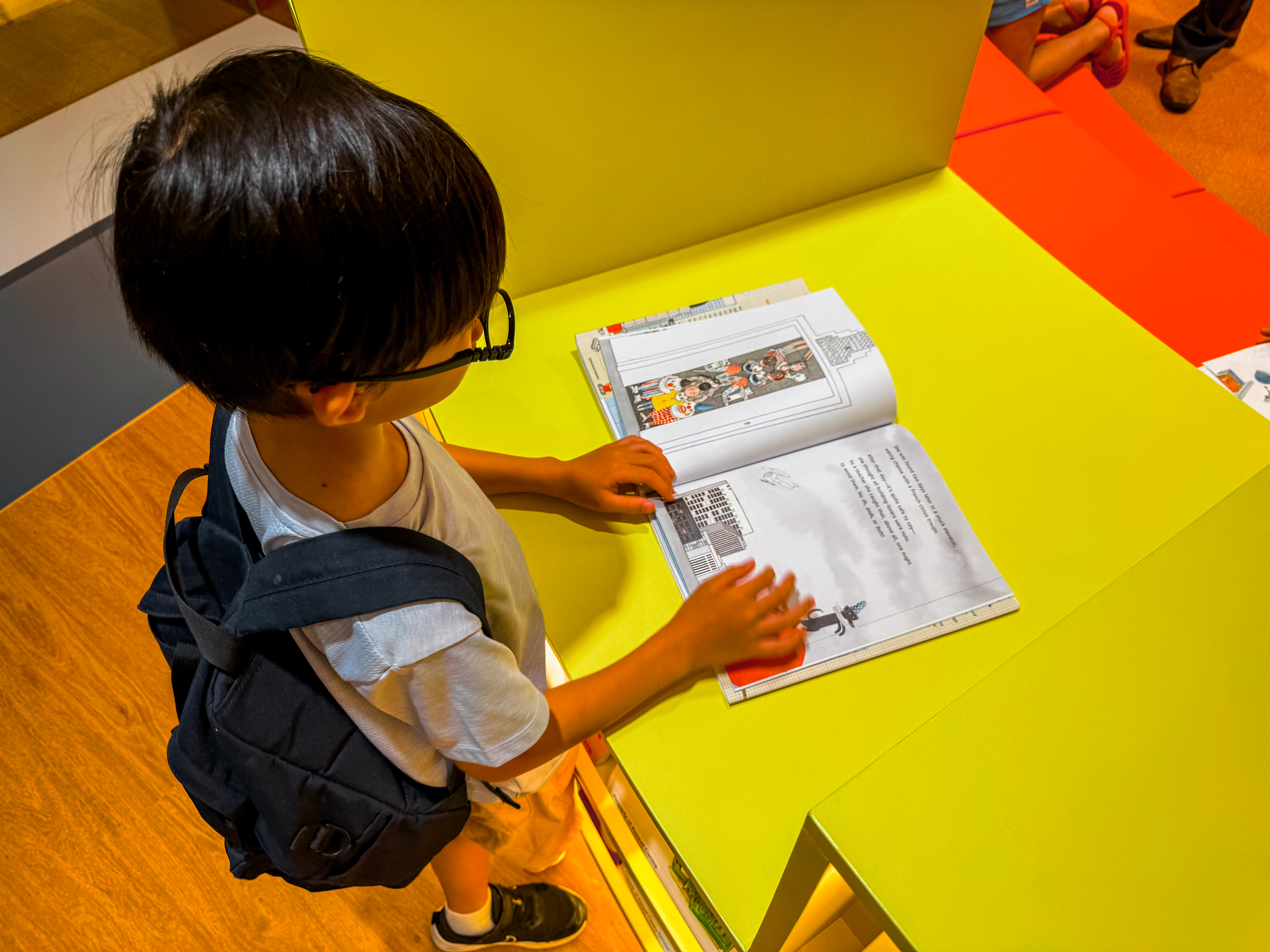 Close up of a young boy reading a book at the Book Nook zone