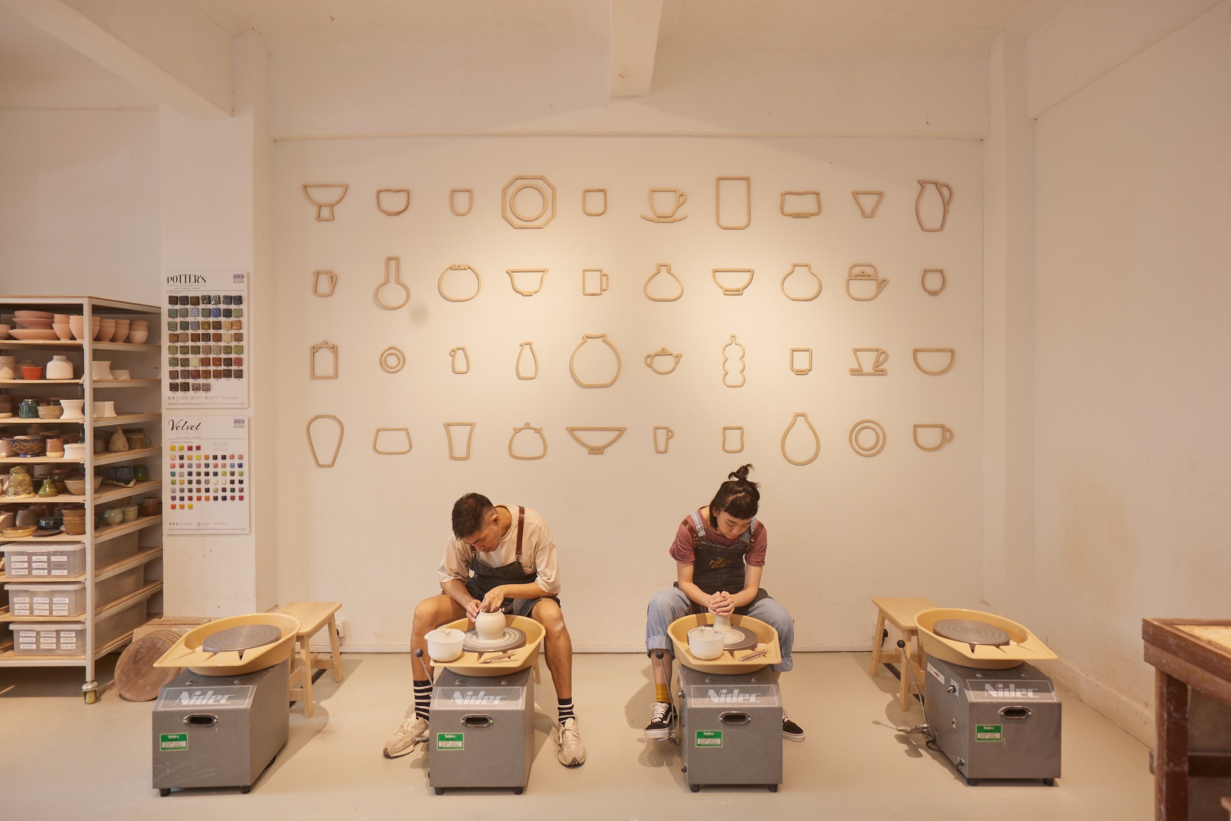 Wide shot of two people doing pottery