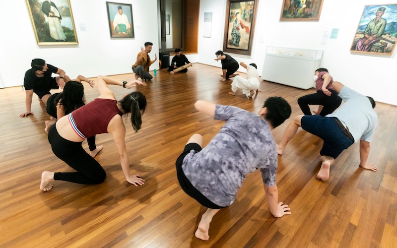  Wide shot of a group of people practising silat in a circle