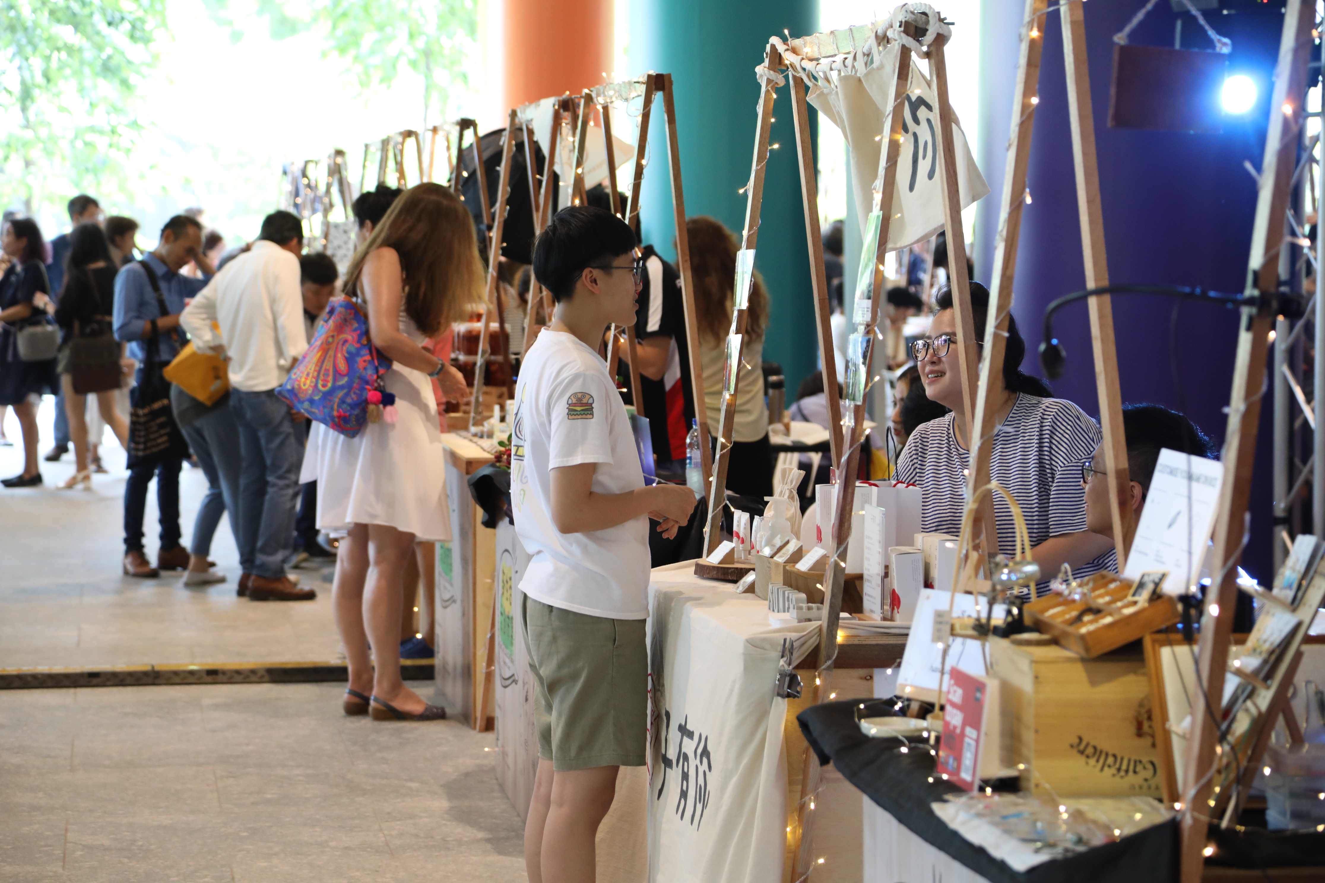 Wide shot of the customers and vendors interacting at the Makers’ Market  