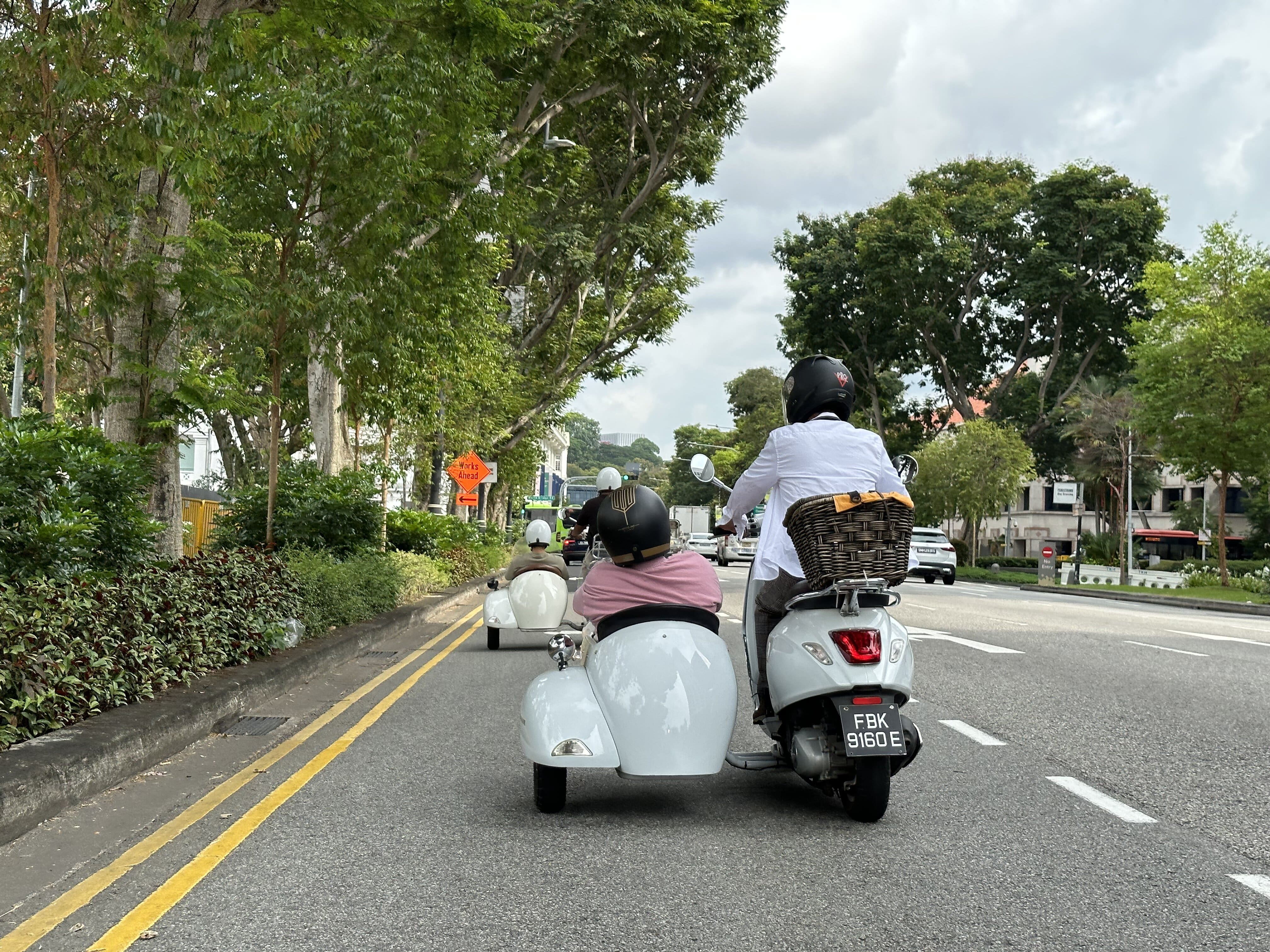 Wide shot of a Vespa sidecar in action on the street