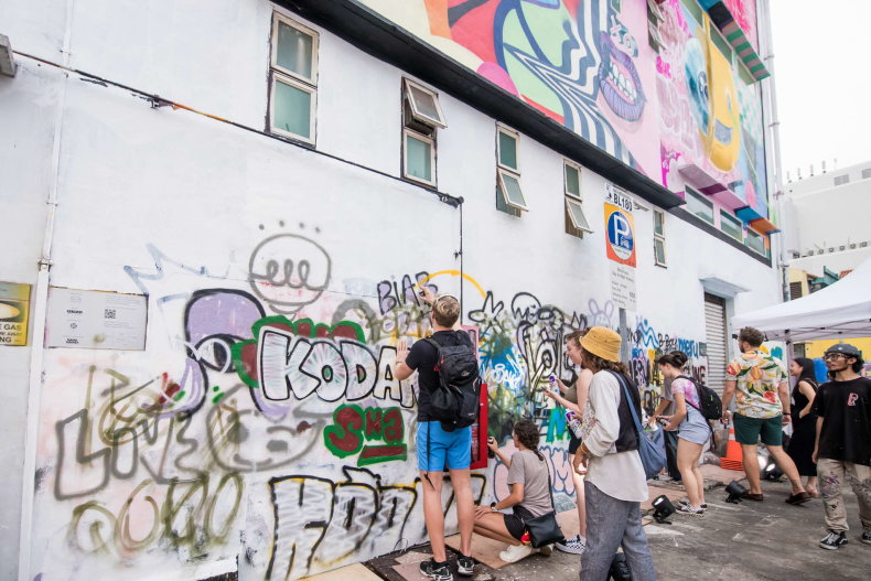 Wide shot of visitors admiring graffiti art 