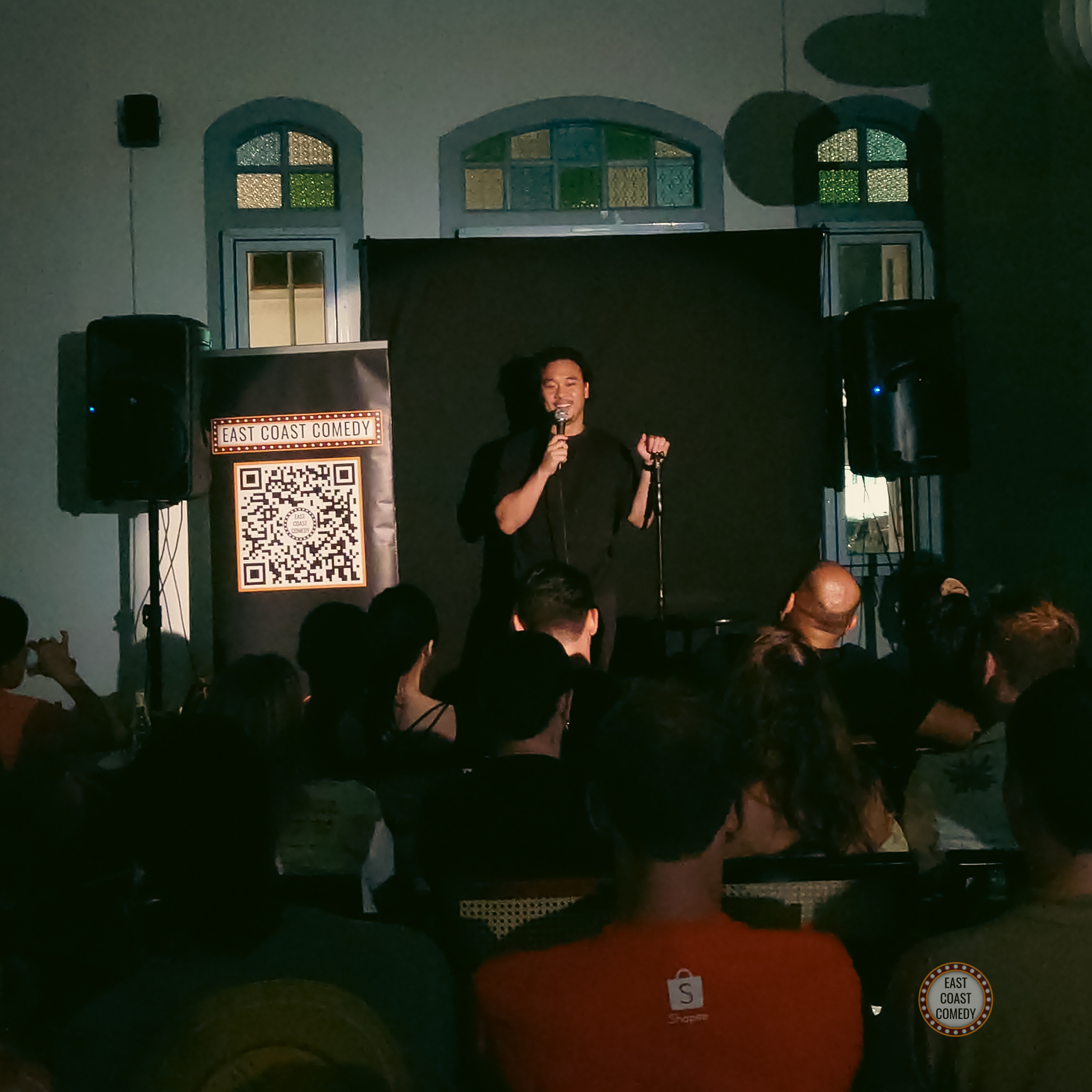 Wide shot of Shawn Chua entertaining a live audience