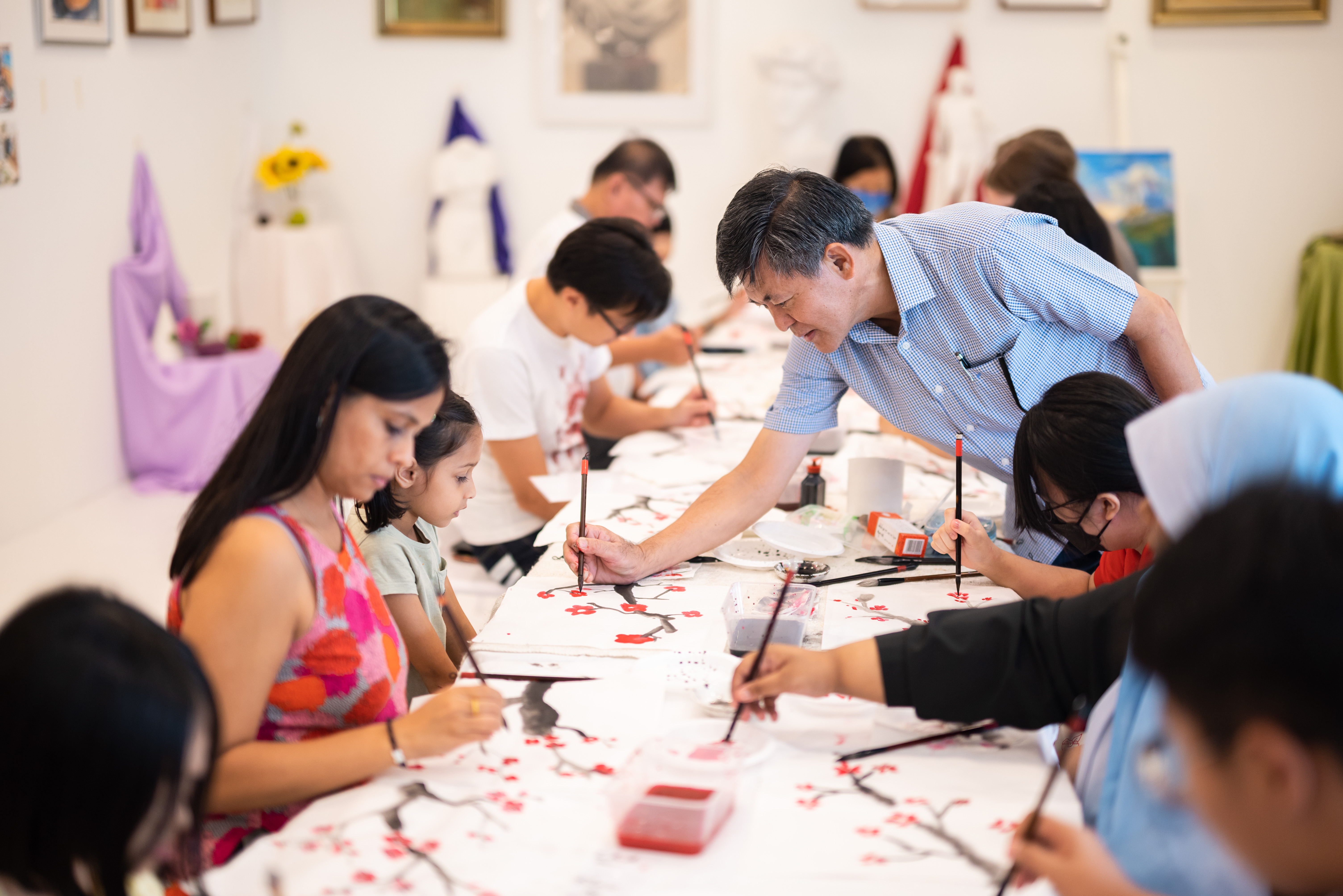 Wide shot of people painting at an arts workshop