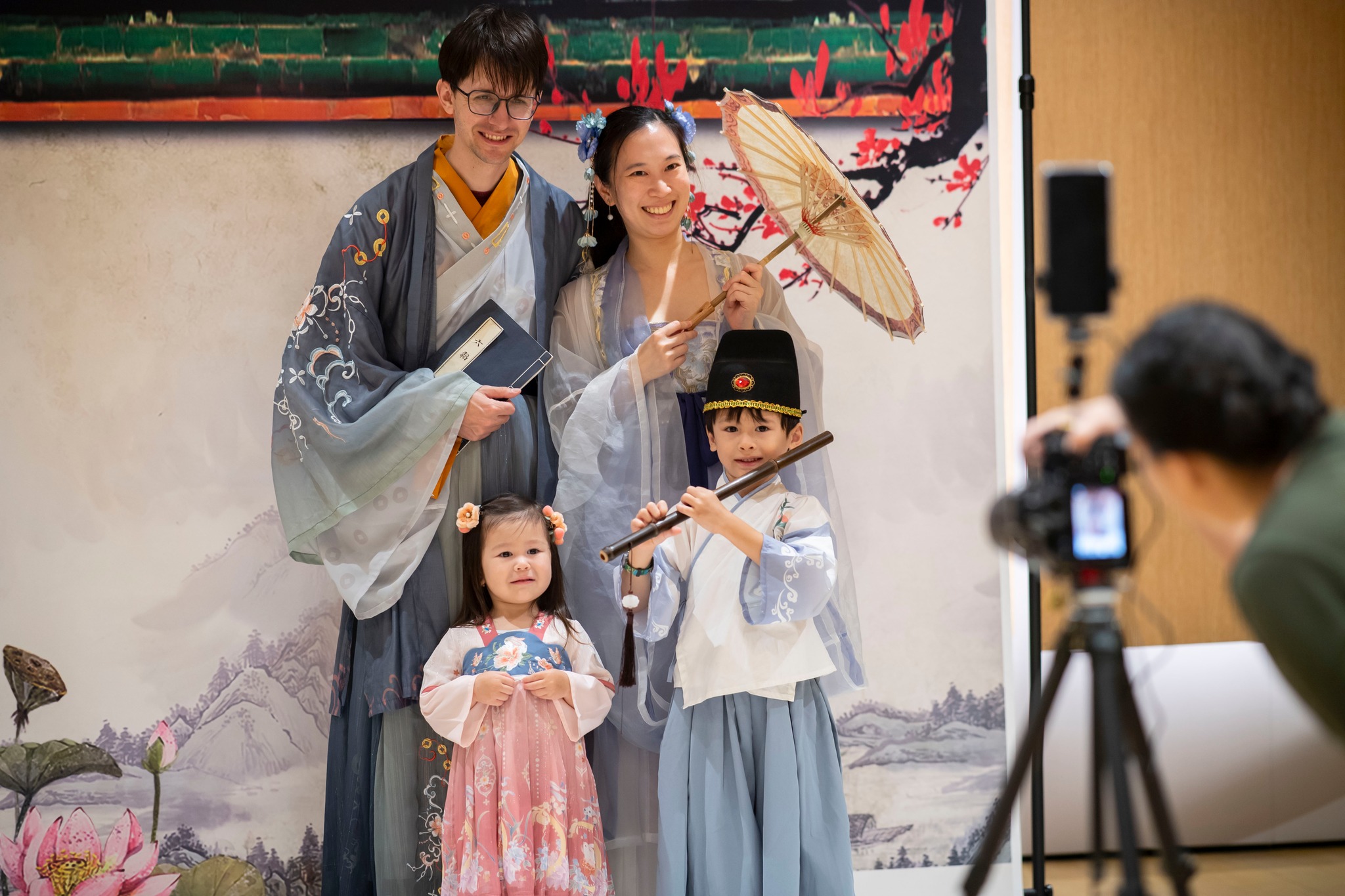 Wide shot of a family of four getting photographed while dressed in hanfu