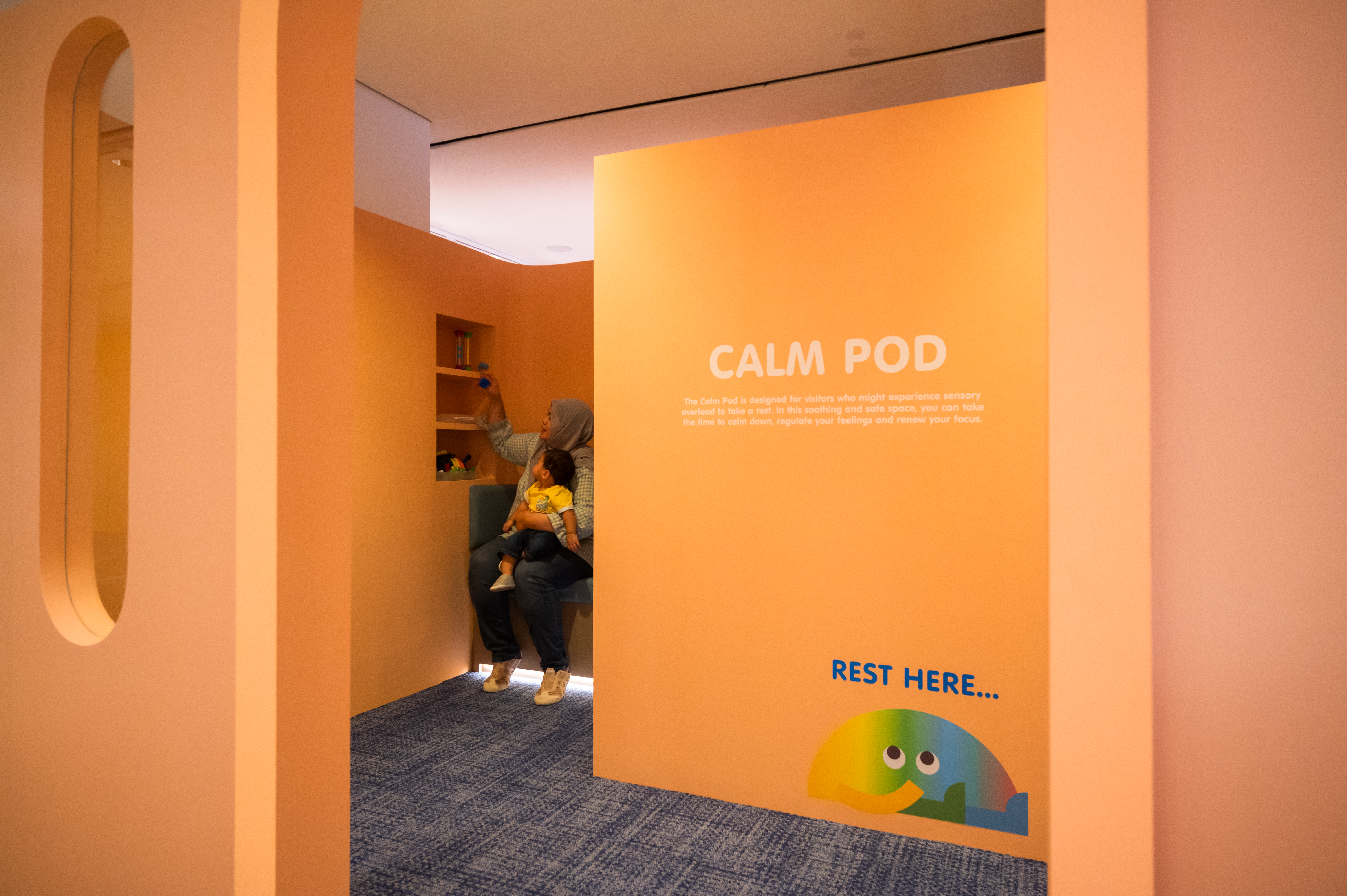 Wide shot of a woman and child resting at the Calm Pod 